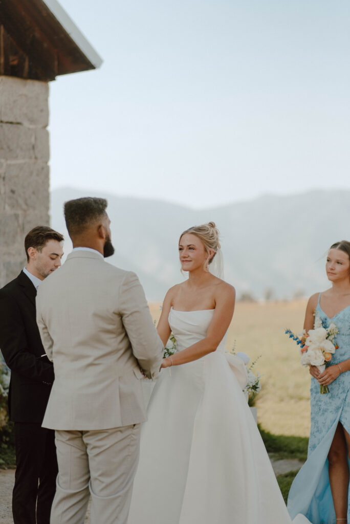 Bride and groom holding hands during their outdoor wedding ceremony.
