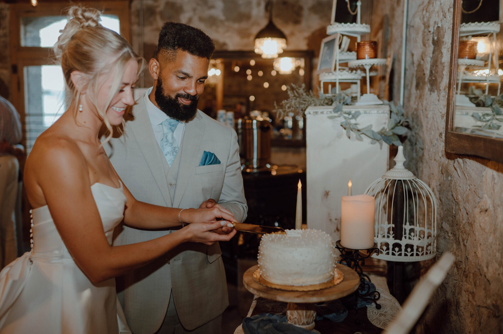 Bride and groom cutting into their small wedding cake during their Gansberg Ranch wedding reception.