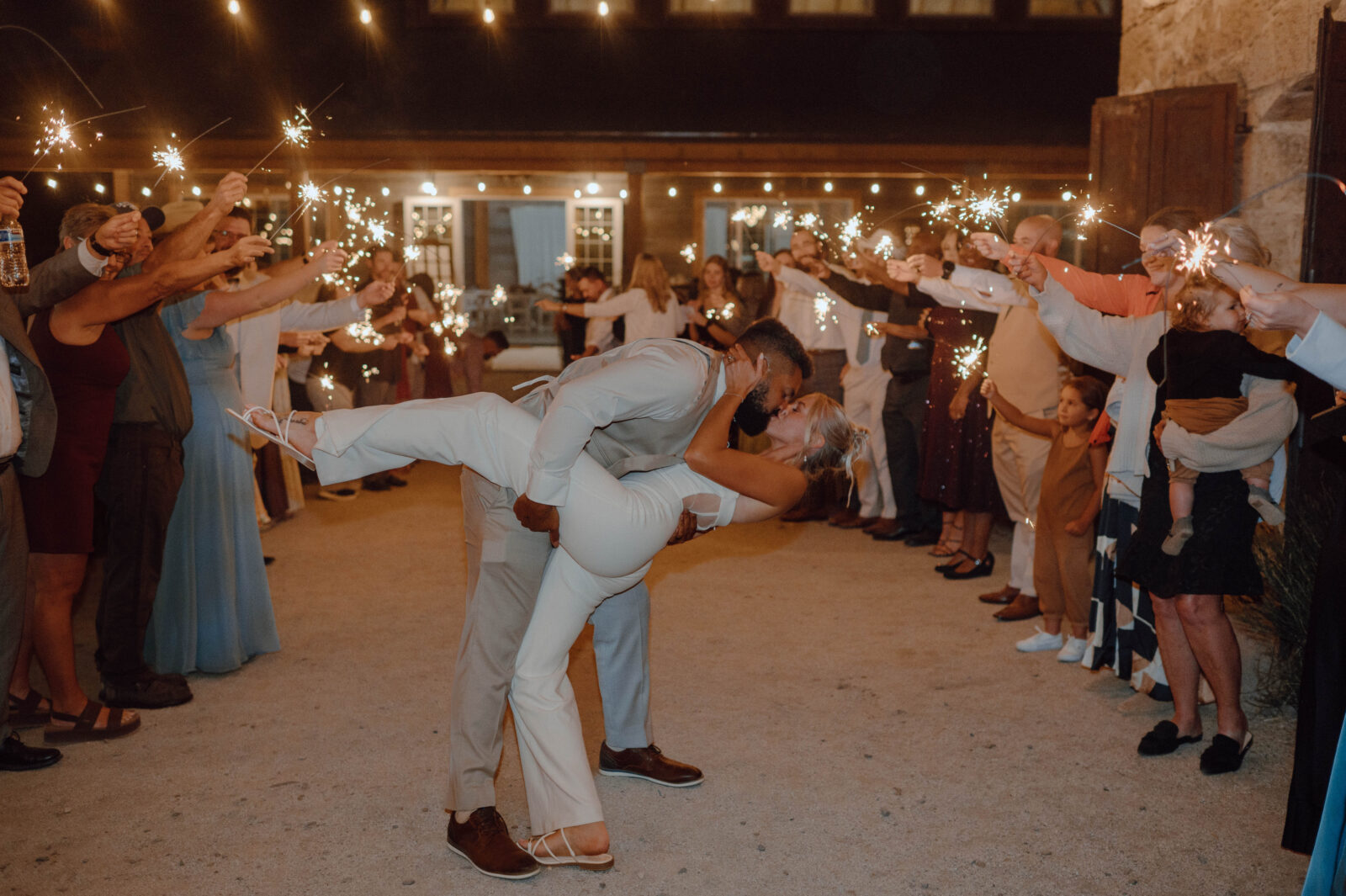 Bride and groom kissing during their sparkler wedding exit.