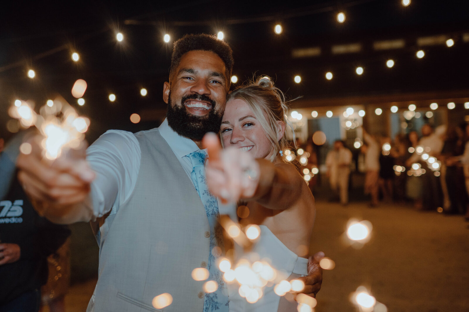 Bride and groom holding sparklers together at the end of their wedding reception.