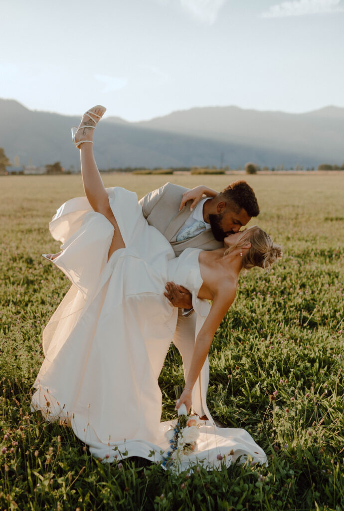 Groom dipping the bride for a kiss during their golden hour wedding photos at Gansberg Ranch.