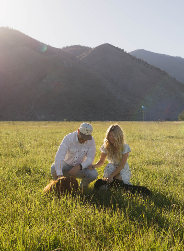 Couple petting their dogs during their golden hour engagement photos in Genoa, Nevada. 