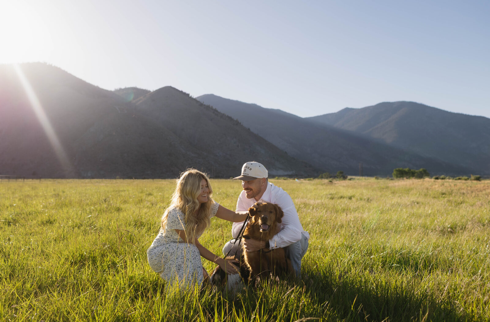 Couple petting their dog during golden hour for their Genona engagement photos in Nevada. 