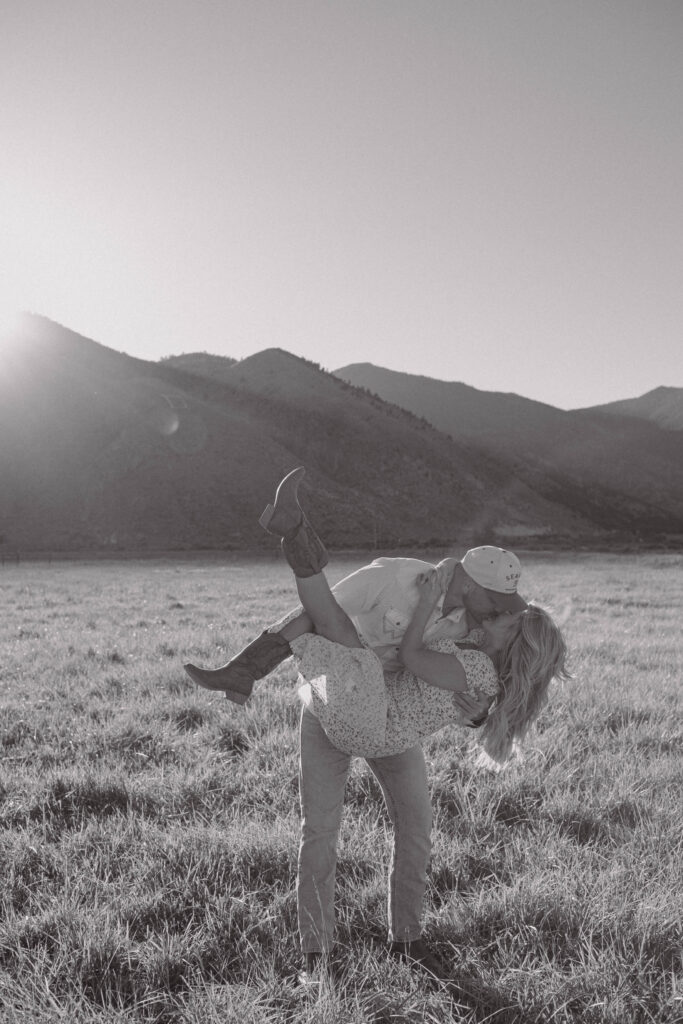 Man lifting and dipping his fiancé during their golden hour engagement photos in Genoa, Nevada. 