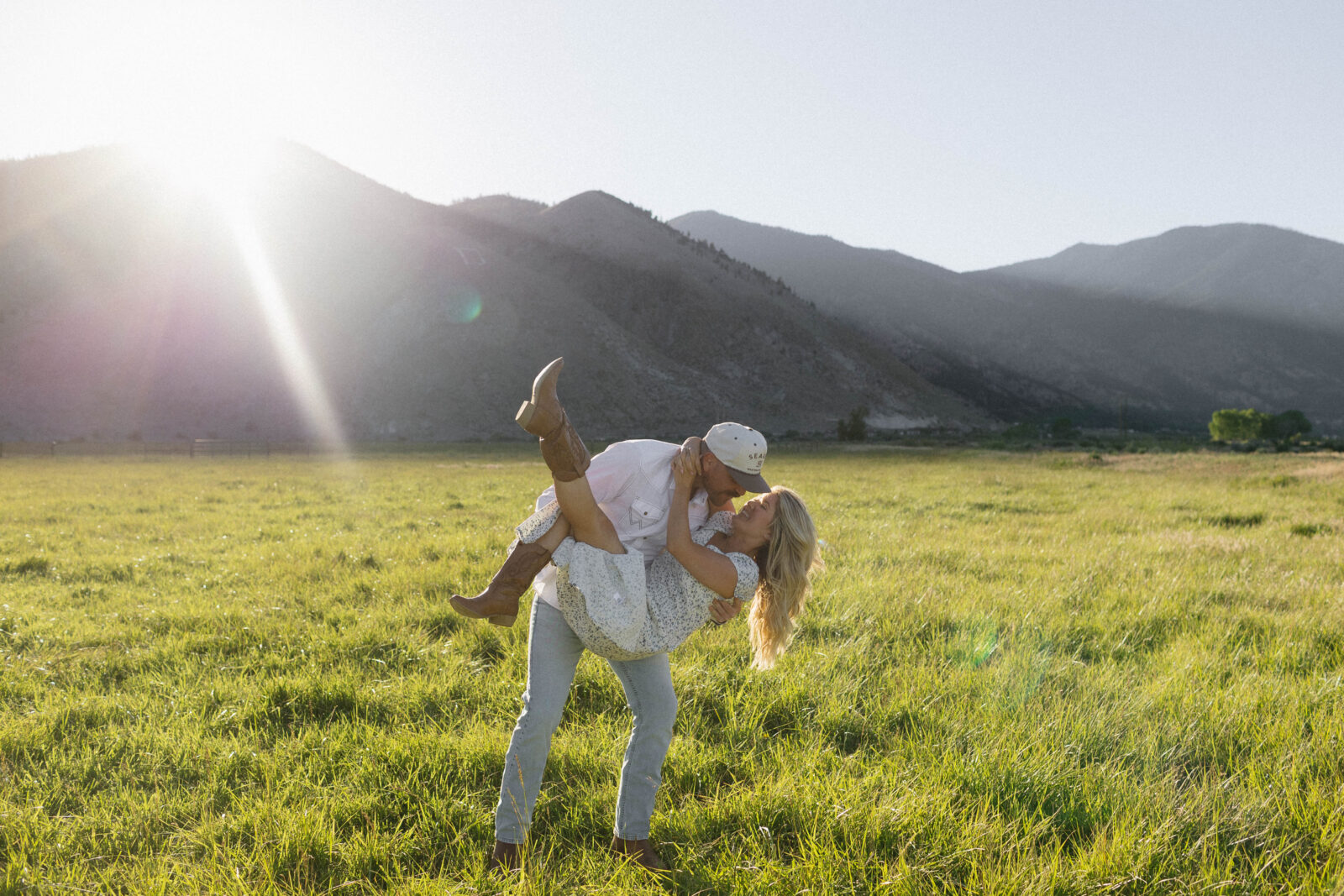 Man lifting and dipping his fiancé during their golden hour engagement photos in Genoa, Nevada. 