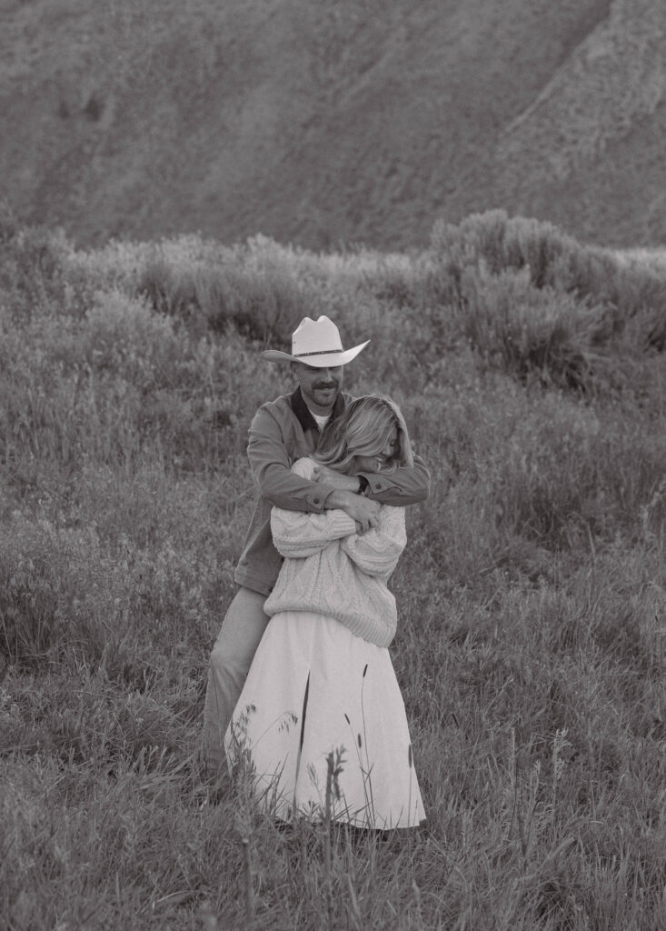 Man holding his fiancé from behind during their engagement session.