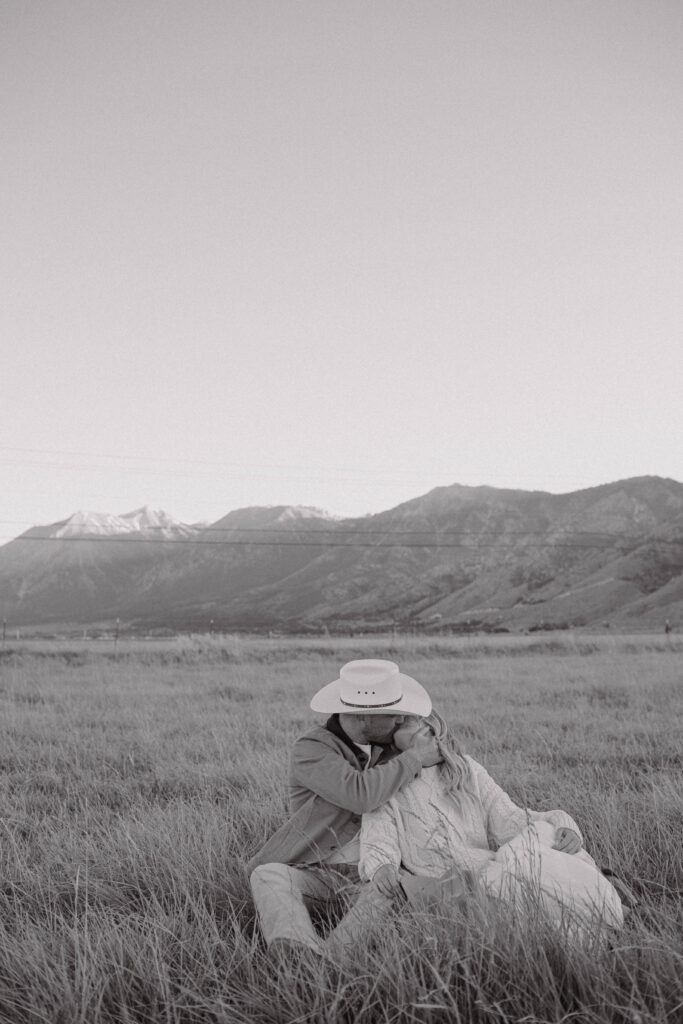 Black and white photo of a couple kissing during their mountain engagement photos in Nevada with Jobs Peak in the background. 
