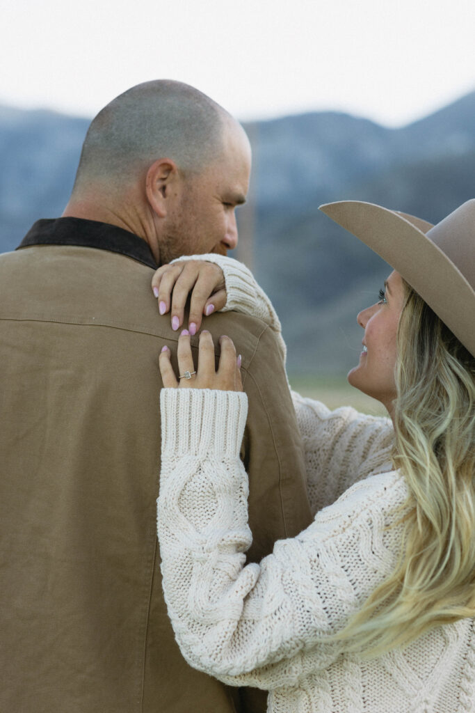 Woman wearing a cowboy hat and posing with her partner for their mountain engagement photos in Genoa Nevada. 