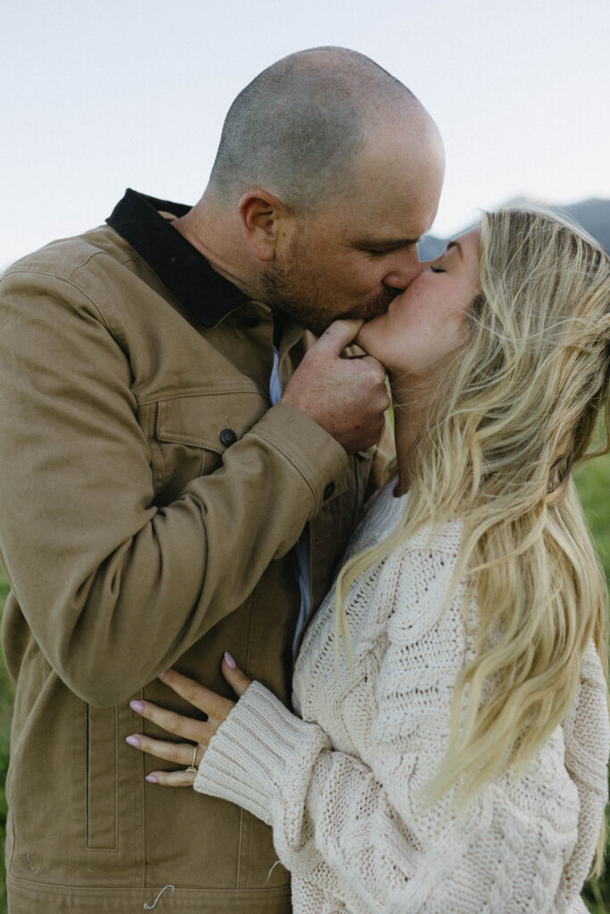 Couple kissing during their engagement session at blue hour. 